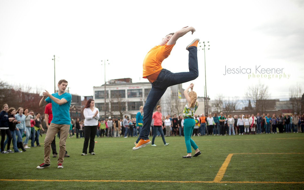 A still of a dancer jumping in the air on a soccer field