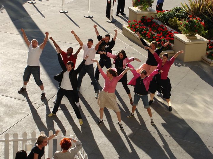 A small group of flash mobbers dancing dressed in 50s clothes
